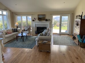 A spacious living room with a fireplace, two sofas, a coffee table, and a view of the outdoors. - Lavender Hill Ranch Santa Ynez: 7 Acre Estate Epic Hilltop Views Near Shops/Wine (Solvang)