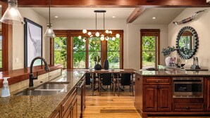 Una cocina con encimeras de granito, microondas integrado y armarios de madera.