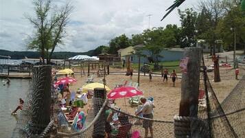 A beach with a rope barrier, umbrellas, and beach chairs.