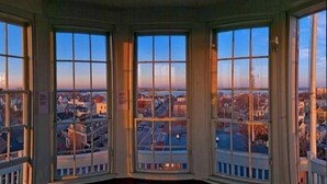 A corner room with large windows offering a city view. - Adorable Portland getaway on the Eastern Promenade (Portland)