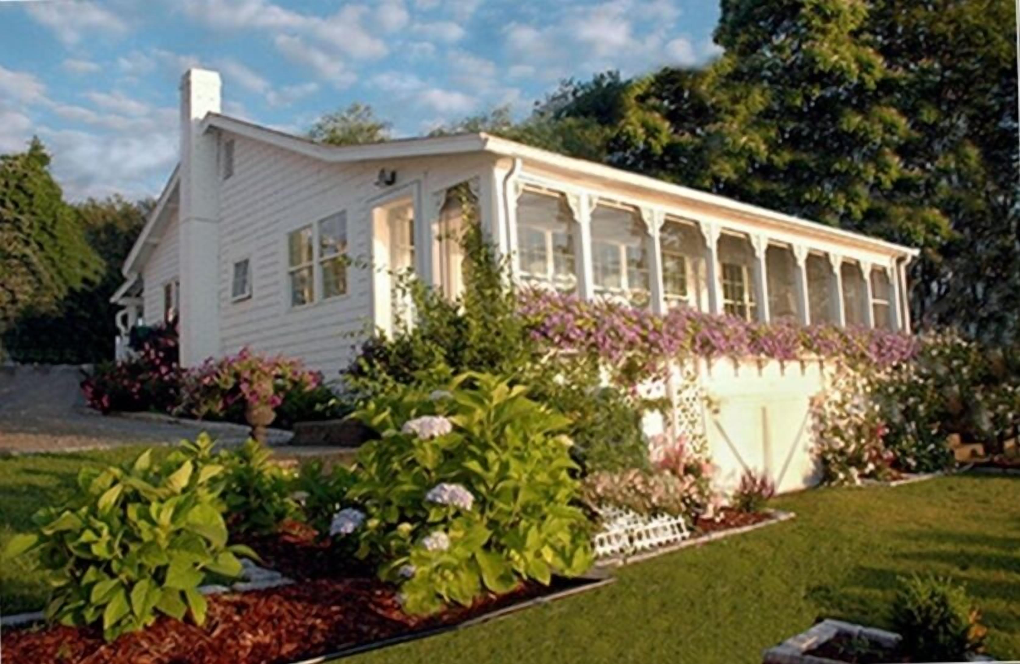 Old fashioned designer front porch living by the sea with expansive water views.