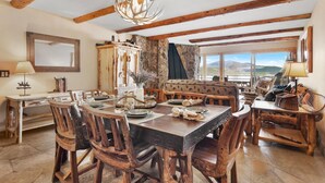 Un comedor rústico con mobiliario de madera, un candelabro y una pared de piedra.