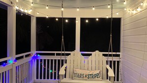 A covered porch with a swing chair and a bench, decorated with string lights. - Grayton Favorite, Large Private Pool, 75 Yards to Beach Access, Newly Renovated (Santa Rosa Beach)