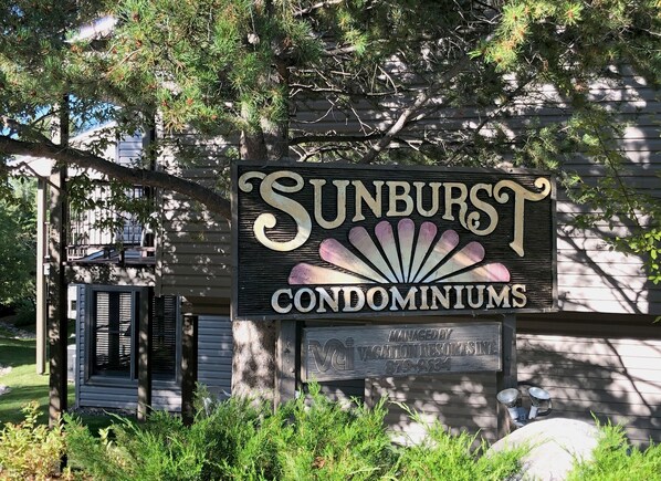 Welcome to Sunburst Condominiums, featuring a gated entrance with a porch area and beautifully landscaped surroundings.