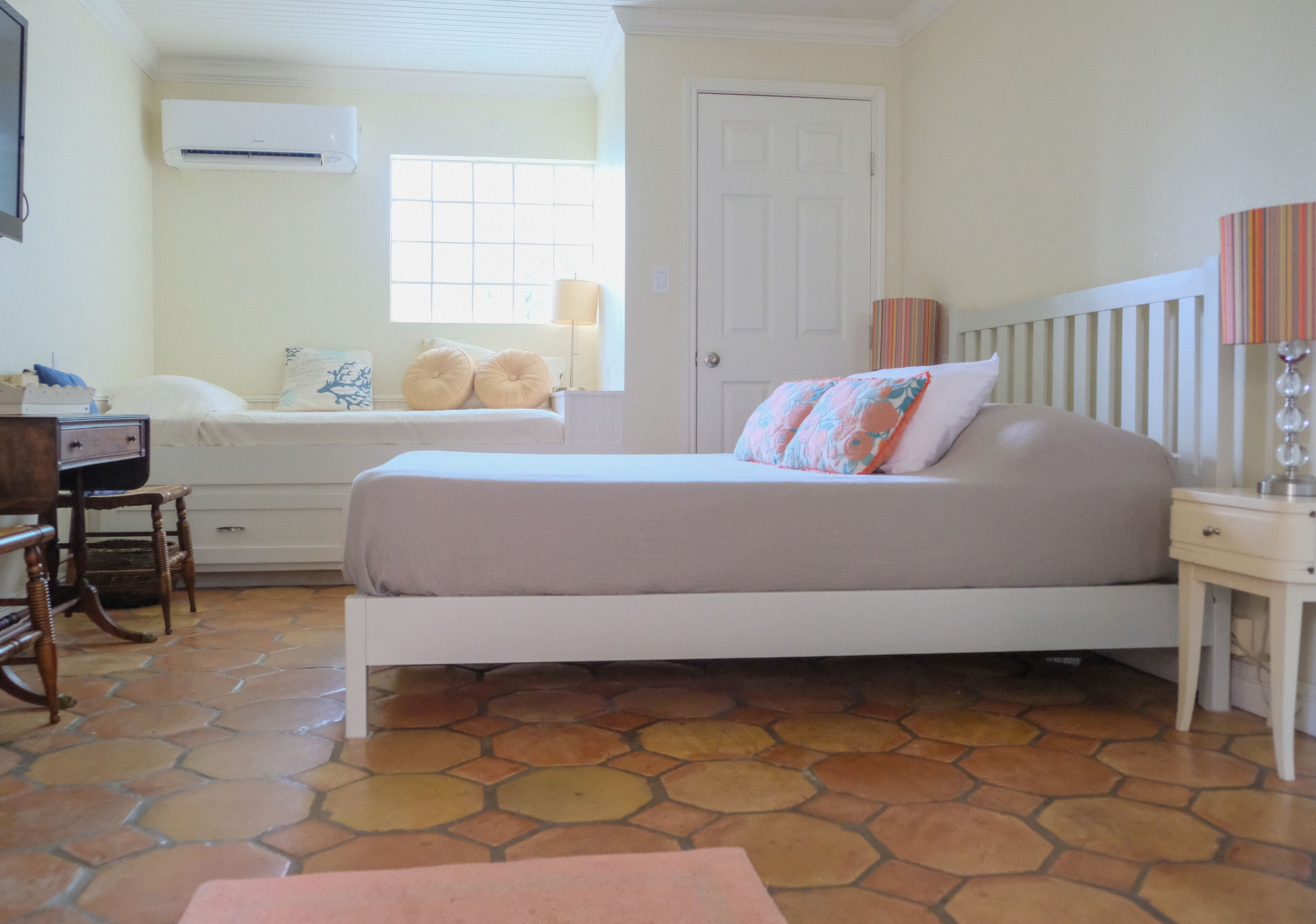 Un dormitorio con cama, escritorio, silla, cómoda y ventana.