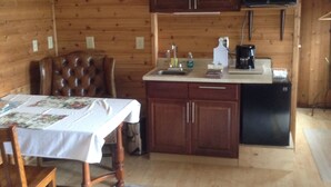 A compact kitchen with wooden cabinets, a microwave, and a coffee maker.