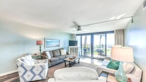 Una sala de estar moderna con un sofá, un sillón, una mesa de centro y un televisor.