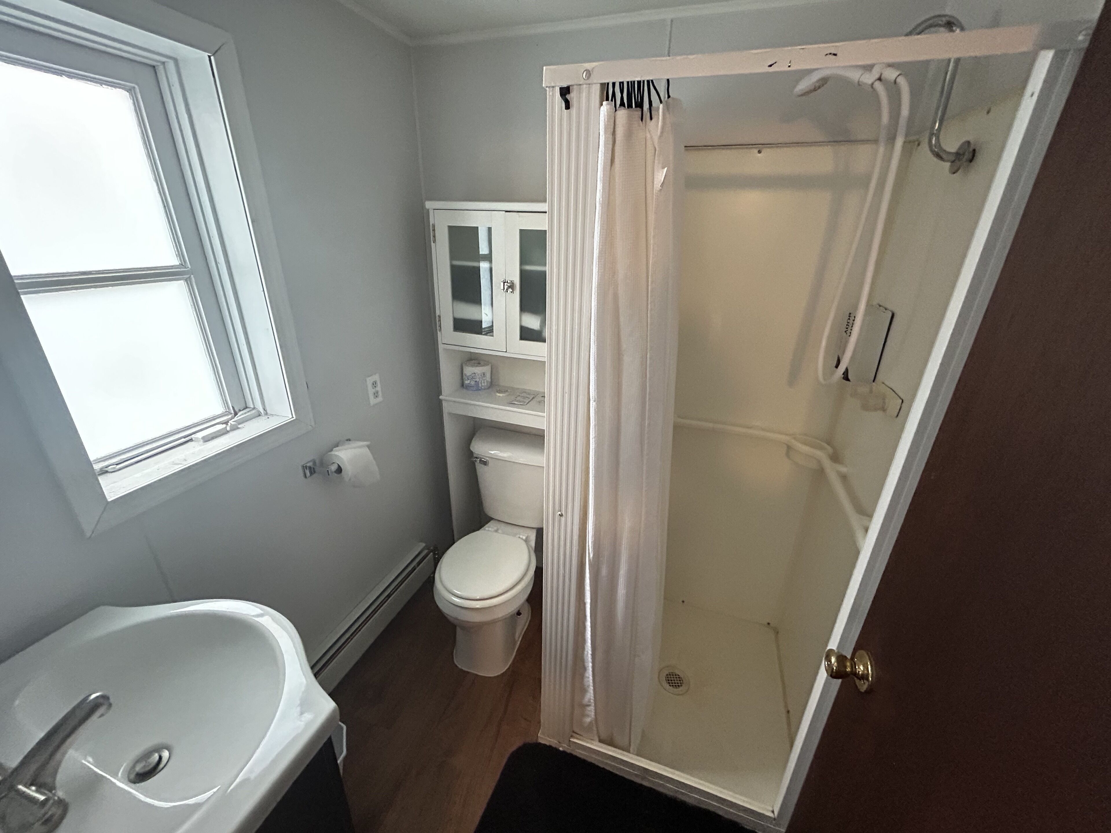 A bathroom with a toilet, sink, and shower.