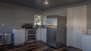 A kitchen with a stainless steel refrigerator, a built-in oven, and a stove. - Spirit Lake Resort Motel (Menahga)