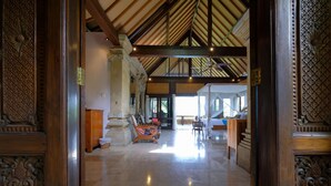 A spacious lobby with a high ceiling, wooden columns, and a central seating area. - Sunrise Villa Ubud (Ubud)