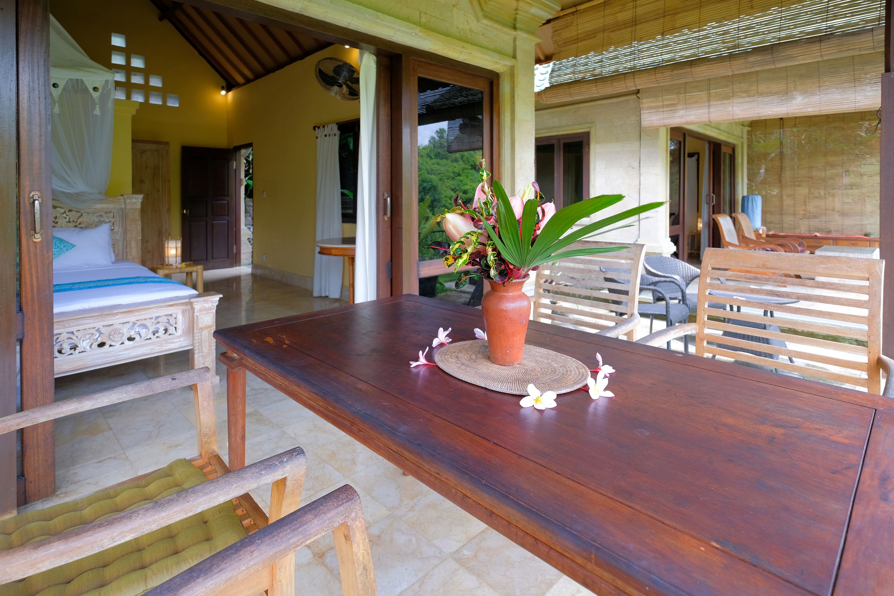 A wooden dining table with a potted plant, surrounded by wooden chairs.