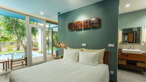 A modern bedroom with a large bed, a bathroom with a sink and mirror, and a view of a swimming pool. - Chay Villas An Bang (Da Nang)