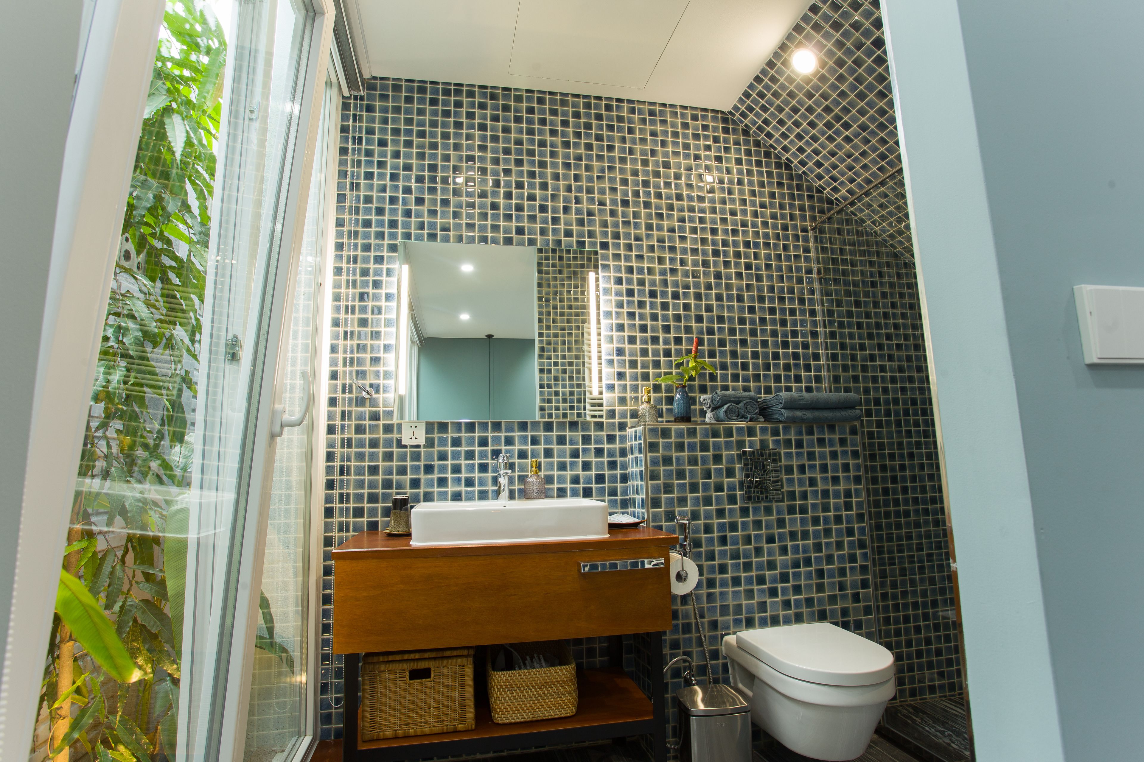 A bathroom with a white sink, a mirror, a toilet, and a shower area.
