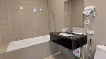 A modern bathroom with a black sink, a mirror, a handheld showerhead, and a toilet.