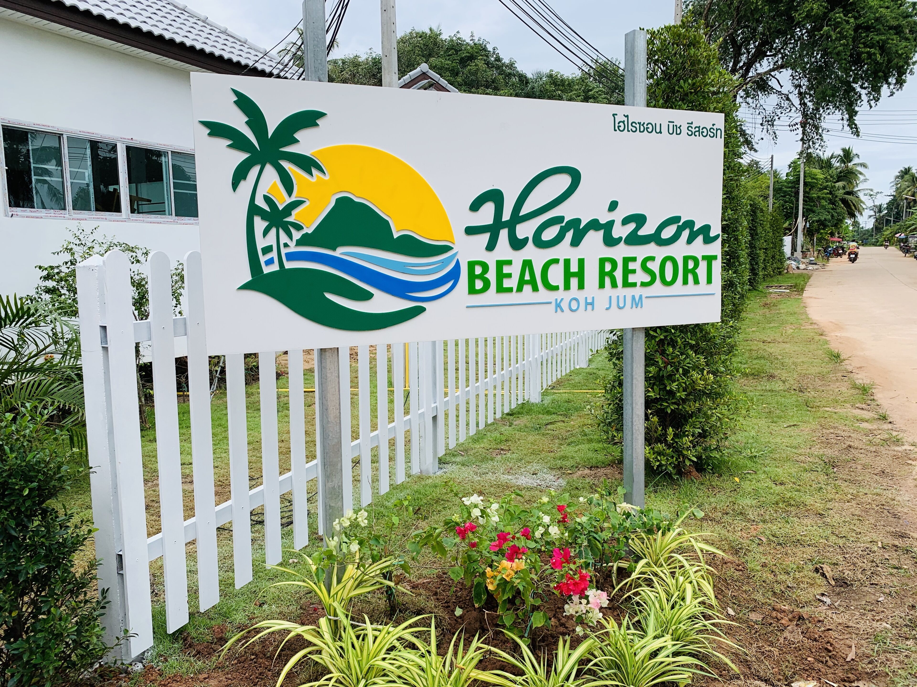 Een bord voor Horizon Beach Resort, met een palmboom en golven logo.