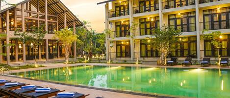 Una piscina al aire libre, sillones reclinables de piscina