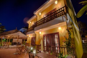 A two-story building with a balcony, outdoor seating area, and a staircase. - An Sen Boutique Villas (Da Nang)