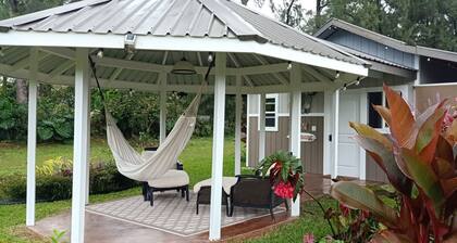 Joli petit chalet sur un verger de fruits tropicaux composé de nombreux fruits.