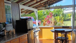 Una cocina con dispensador de agua, estufa y una mesa con sillas.