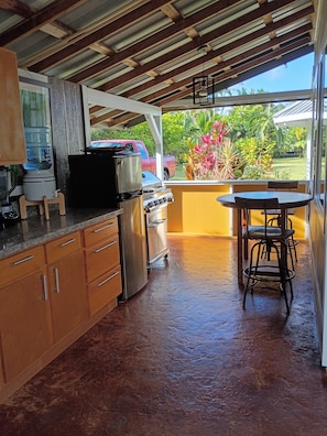 Una cucina con un distributore d'acqua, un fornello e un tavolo con sedie.