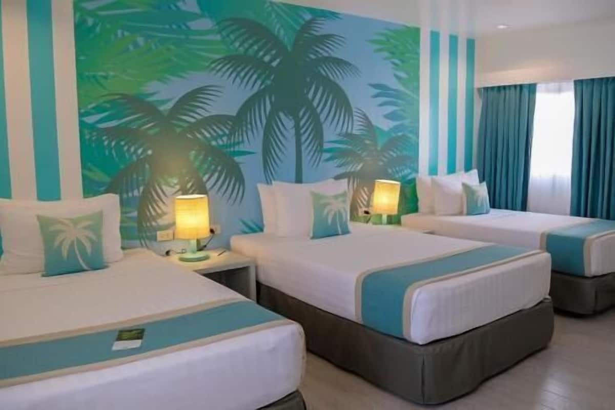 Quarto de hotel com duas camas, cada uma com travesseiro e mesa de cabeceira com abajur.