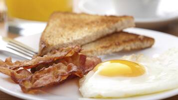 A plate with toast, bacon, and a fried egg.