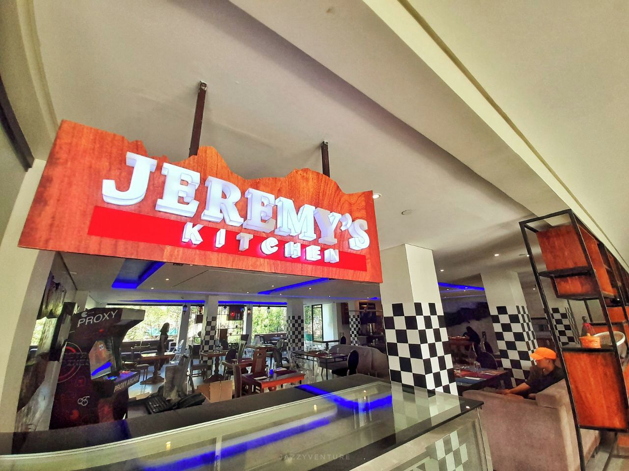 En restaurang som heter ”Jeremys kök” med ett rutmönstrat golv och en modern inredning.