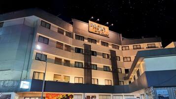 Un hotel de varios pisos con un letrero destacado que dice “PROXY” y un anuncio de servicios de spa.