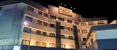 Un hotel de varios pisos con un letrero destacado que dice “PROXY” y un anuncio de servicios de spa.