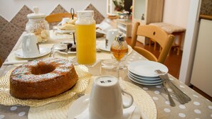 Una mesa de desayuno con un pastel bundt, un vaso de jugo de naranja y una taza de café.