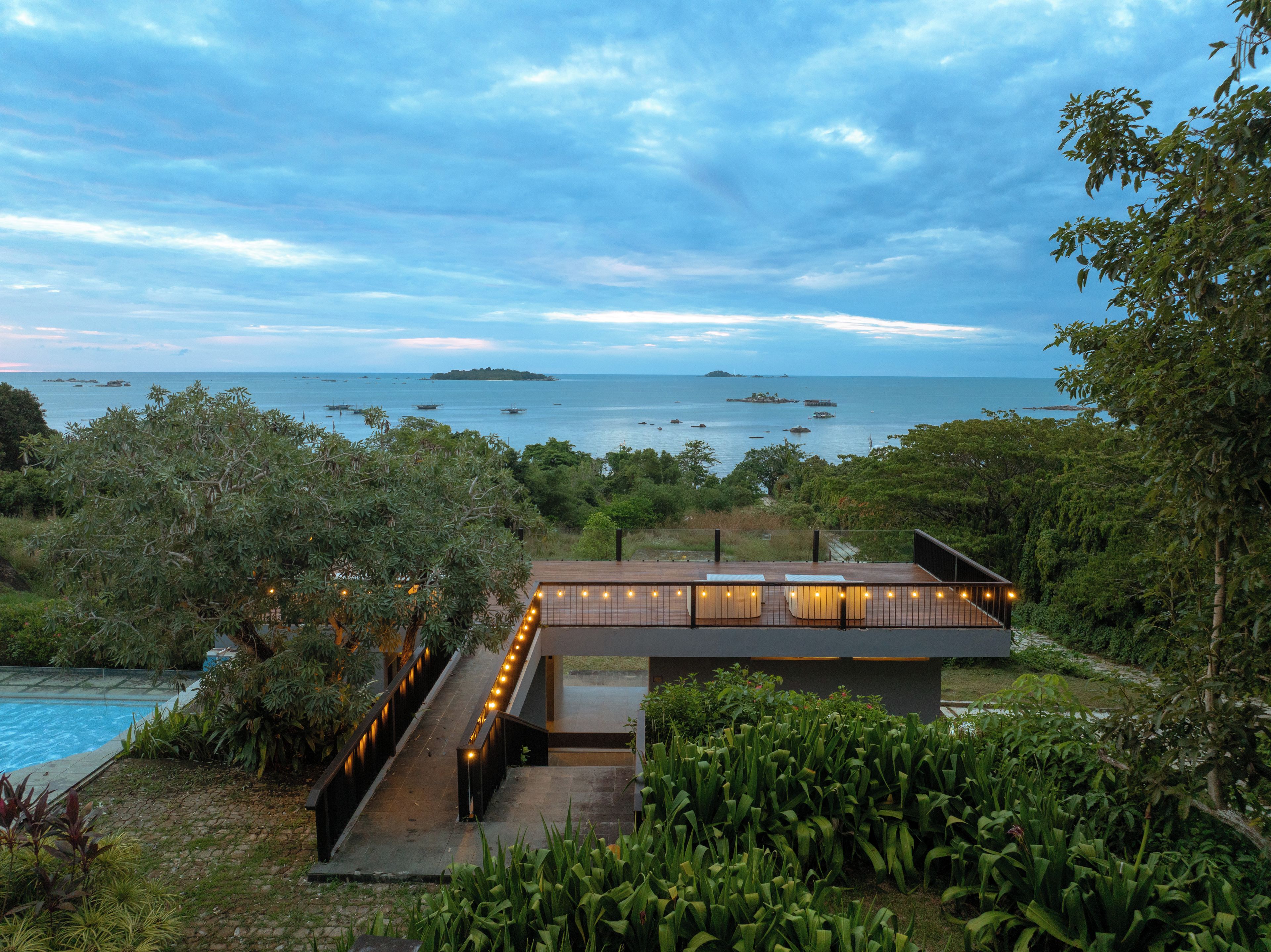 A modern outdoor deck with a view of the sea and distant islands.
