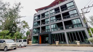 A multi-story building with a modern architectural design, featuring large windows and balconies. - The Kris BangTao by Lofty (Choeng Thale)