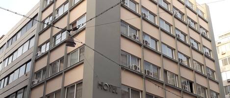 Un hotel de varios pisos con un llamativo letrero 'HOTEL' en la fachada.