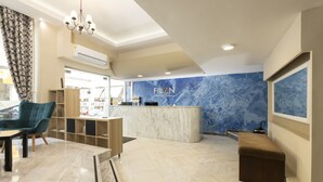 A hotel reception area with a marble counter, a blue marble wall, and a reception desk.