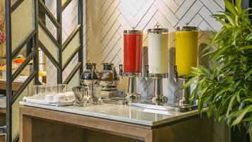 A bar area with a herringbone tile backsplash, a bar counter, and a plant on the right.