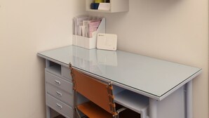 A corner desk with a chair, a white drawer unit, and three wall-mounted shelves with various items. - Stylish flat by the beach of Edem (Palaio Faliro)