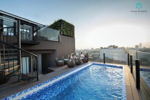 A rooftop pool area with a glass balustrade, seating, and a city view. - Solare De Monte Hotel & Spa (Hanoi)