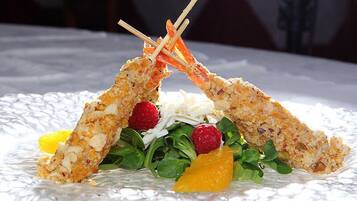 Un plat de fruits de mer agrémenté d’une présentation décorative de légumes verts et de fruits.