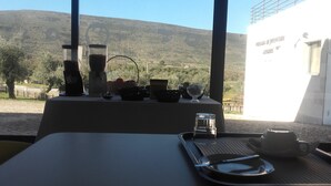 A table set for breakfast with a view of a mountainous landscape. - HI Alvados - Pousada de Juventude - Hostel (Porto de Mos)