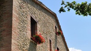 A stone building with multiple windows, some with flower boxes. - Girfalco - Country House - Bed&Breakfast (Urbino)
