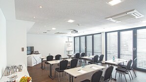 A modern conference room with a whiteboard, projector, and large windows.