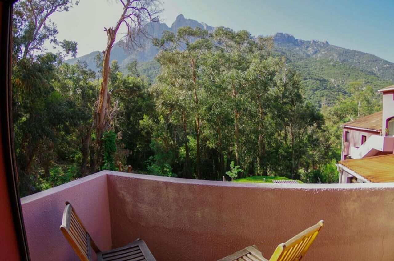 A balcony with a view of a forest and mountains.