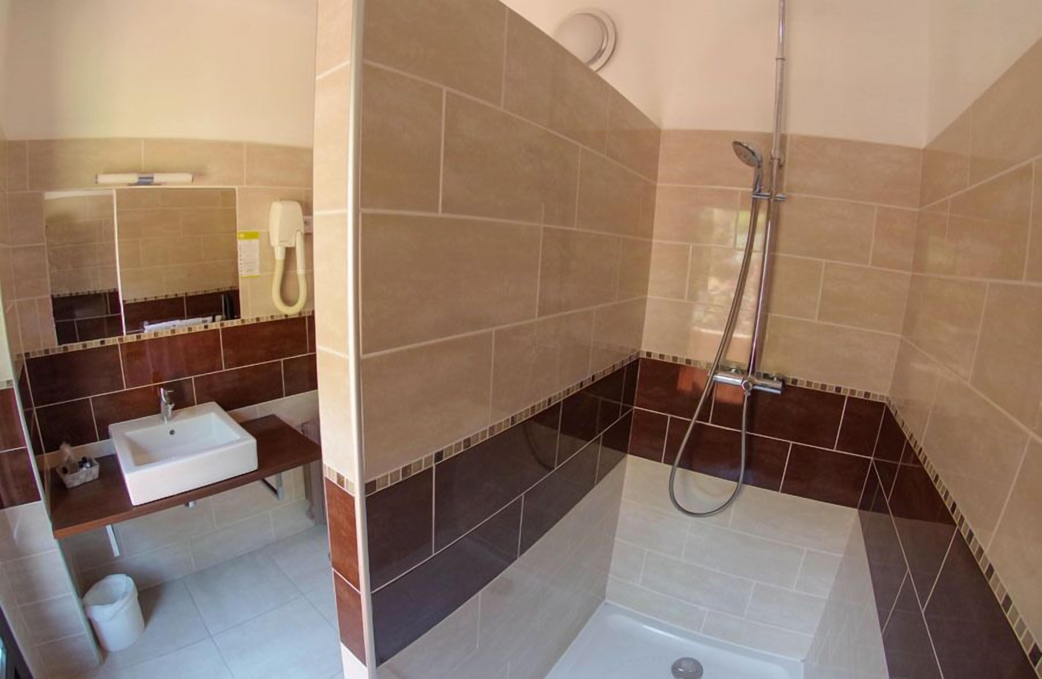 Un baño con lavamanos, espejo y ducha.