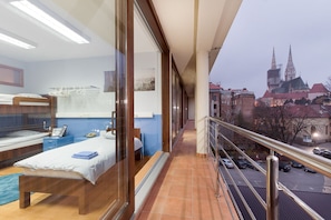 A balcony with a view of a cityscape, including a church spire. - Hostel Bureau (Zagreb)