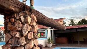 Un pilar de piedra con una escultura de jirafa en la parte superior, una piscina y un edificio con un letrero al fondo.
