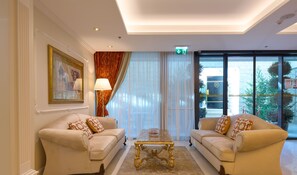 A well-lit room with two sofas facing each other, a small table, and a large window with a view of the outside. - Hotel Villa Harmony (Split)