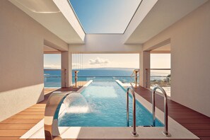 A pool area with a clear view of the sea, a skylight, and wooden decking. - Hotel Villa Harmony (Split)
