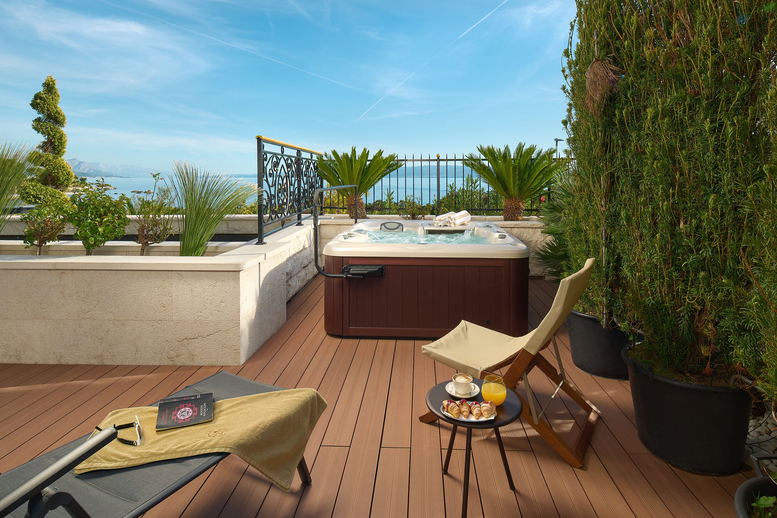 Una terraza en la azotea con hidromasaje, sillones de descanso y una mesa con aperitivos y bebidas.
