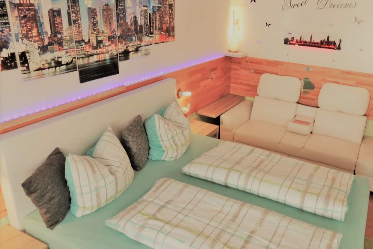 A cozy room with a sofa, a small table, and a cityscape wall art.
