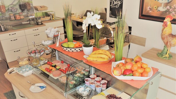 Ein Buffet mit verschiedenen Speisen, darunter Obst, Käse und Fleisch.